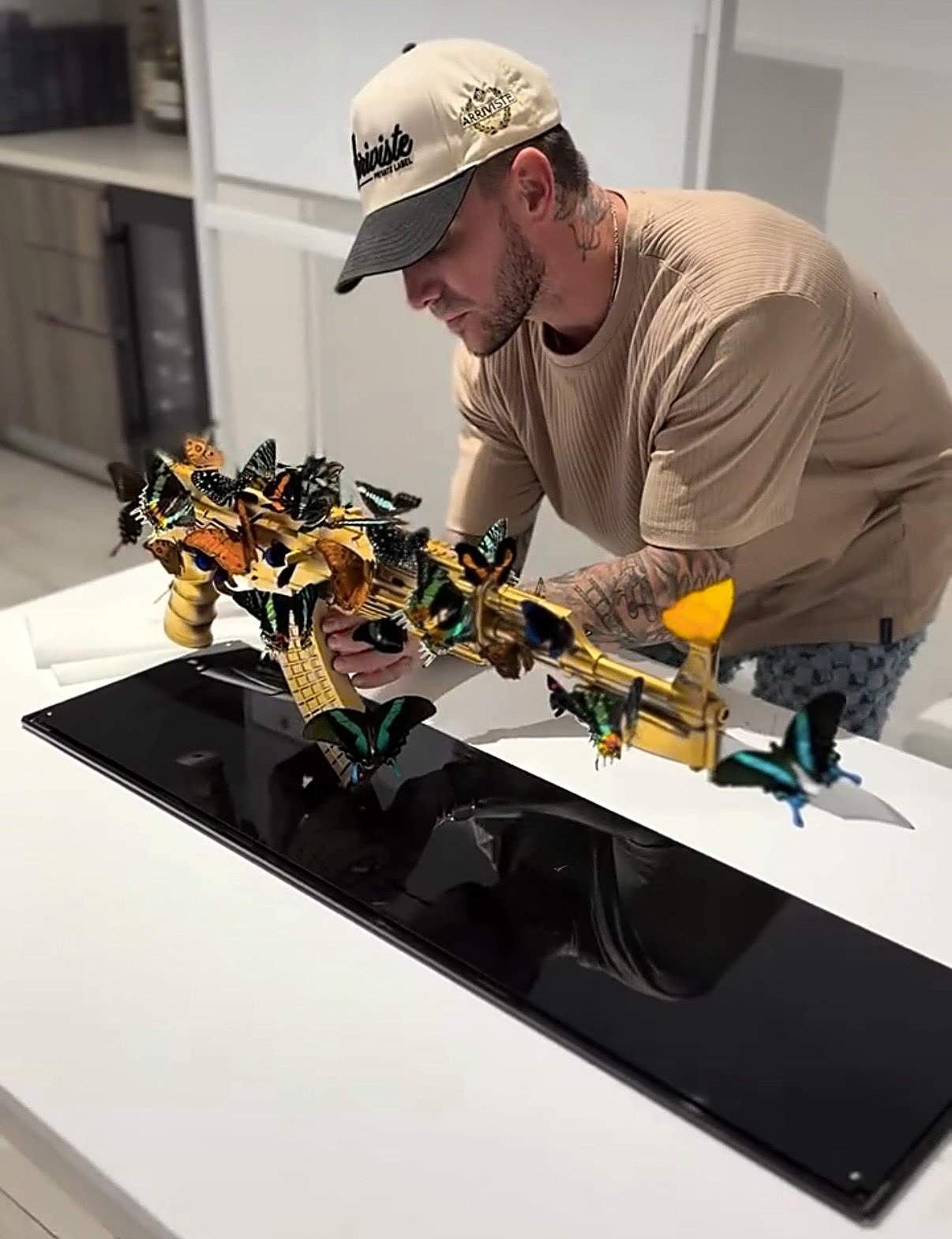 Justin Lubas placing a gold butterfly-covered piece onto its black base